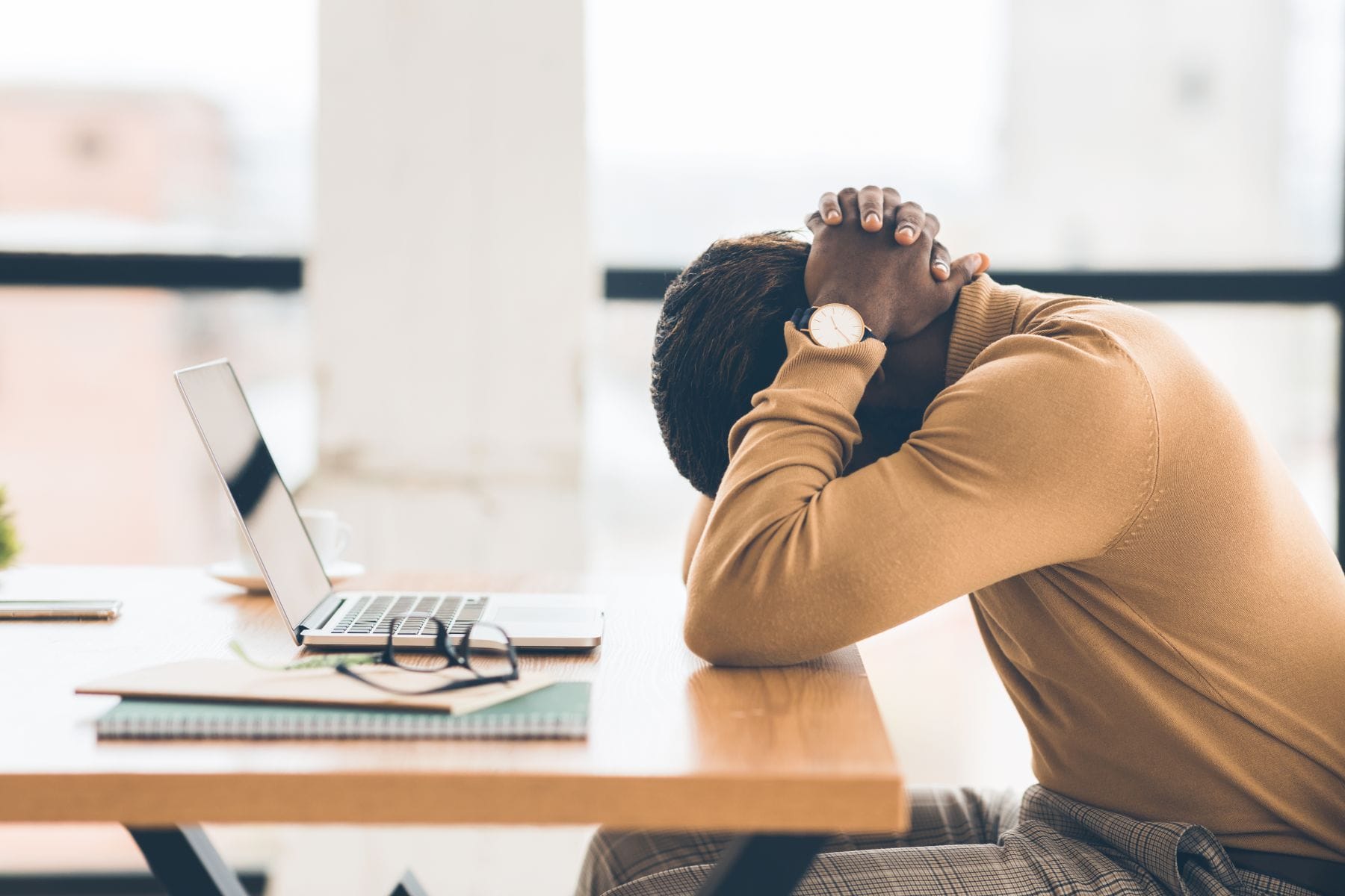 Problems At Work. Black businessman feeling upset and desperate, working at office, hands on head. Free space